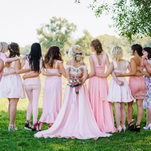 Kobiety w różowych sukniach stojące tyłem